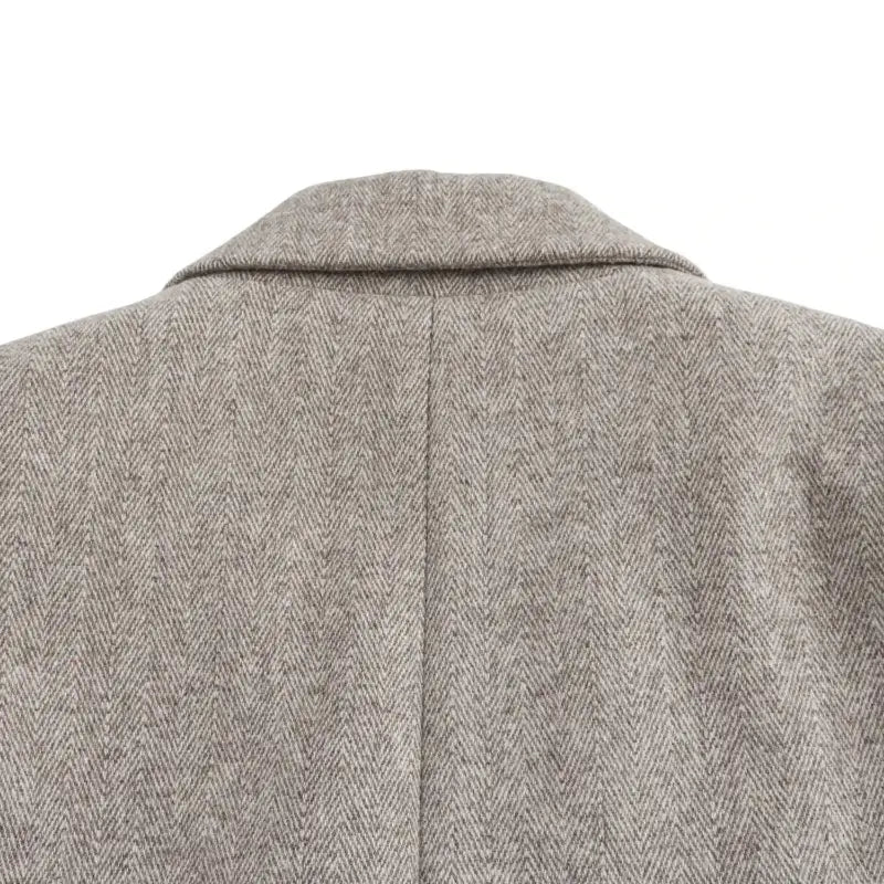 Close-up da gola e parte superior das costas do blazer feminino bege.