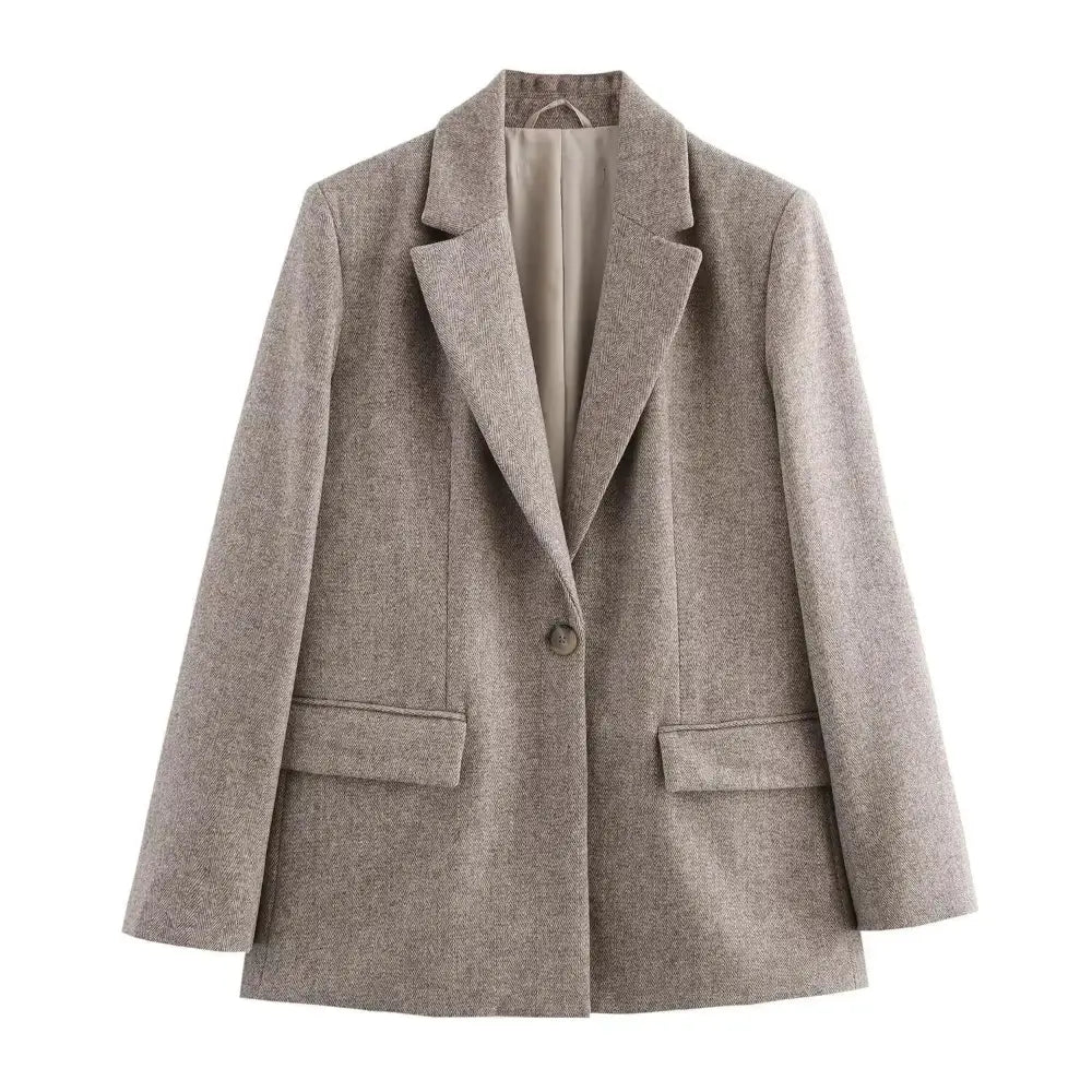 Blazer feminino de alfaiataria bege, com gola e lapelas, fechamento por botão único e bolsos com lapelas, exibido em fundo branco.