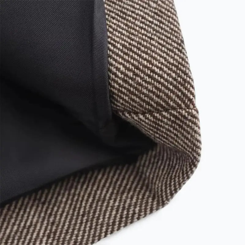 Close-up detalhado da textura do tecido do blazer feminino marrom de alfaiataria, exibindo as forro e as fibras da malha.