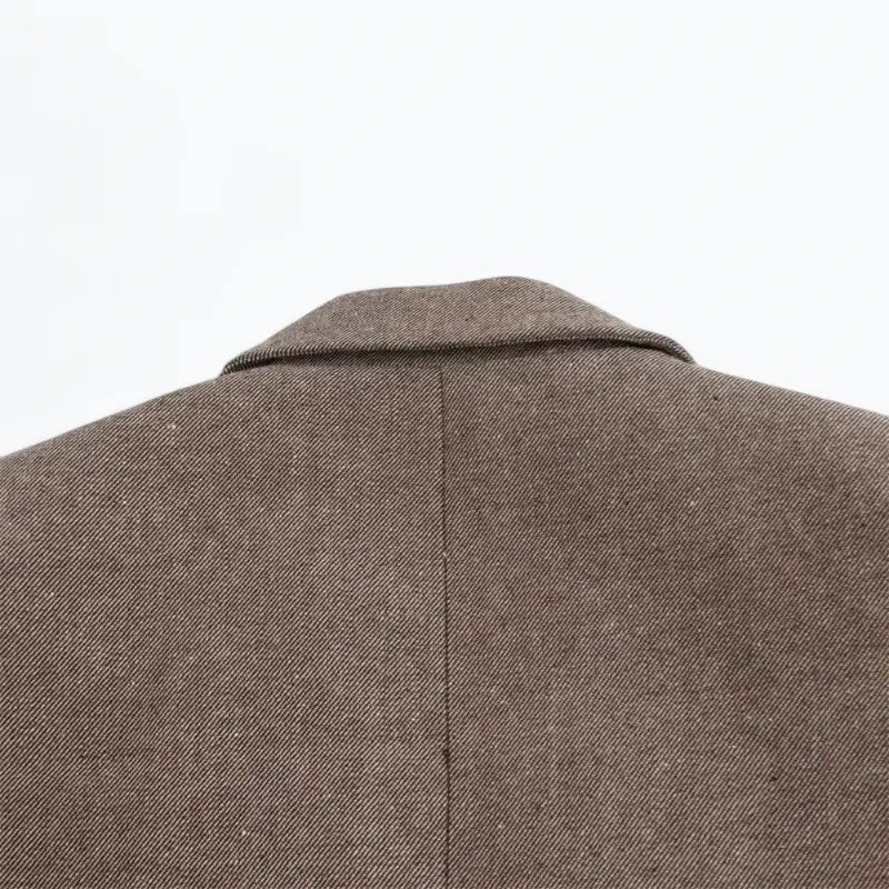 Close-up da gola e parte superior das costas do blazer feminino marrom.