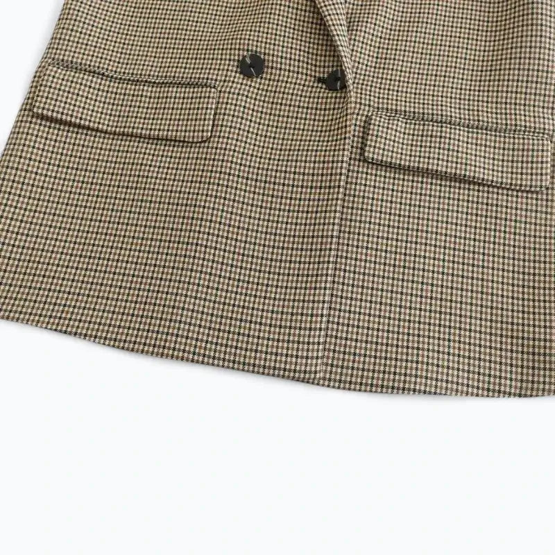 Close-up da parte inferior do blazer feminino xadrez, com botões pretos e bolsos chapados com lapela, exibindo o padrão miúdo.