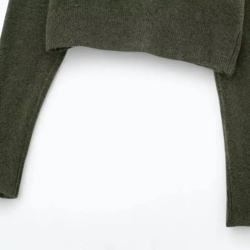 Close-up da barra e punhos do cardigan feminino curto verde, detalhando o acabamento canelado.