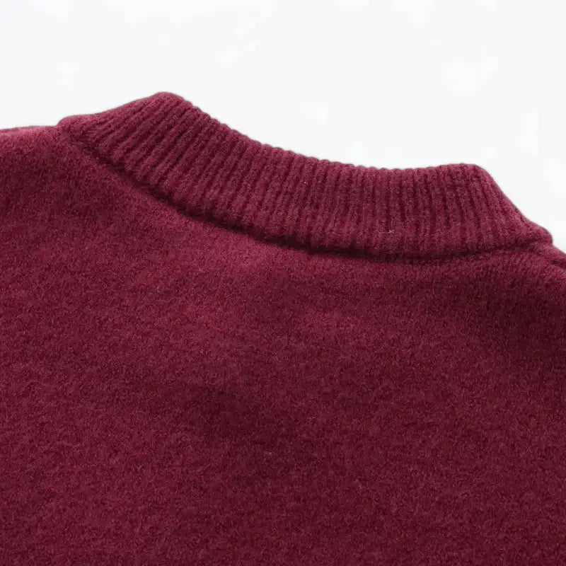 Close-up da gola redonda canelada e parte superior das costas do cardigan feminino vermelho, destacando a textura felpuda.