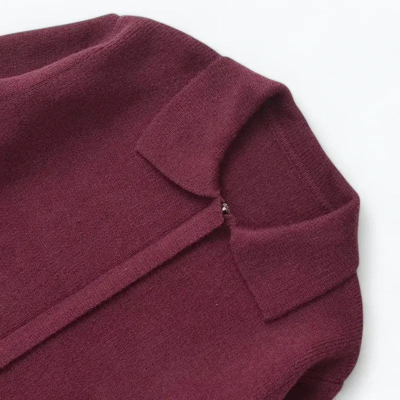 Close-up da gola estilo camisa do cardigan feminino vermelho, com detalhe do zíper, fechamento frontal e textura da peça.