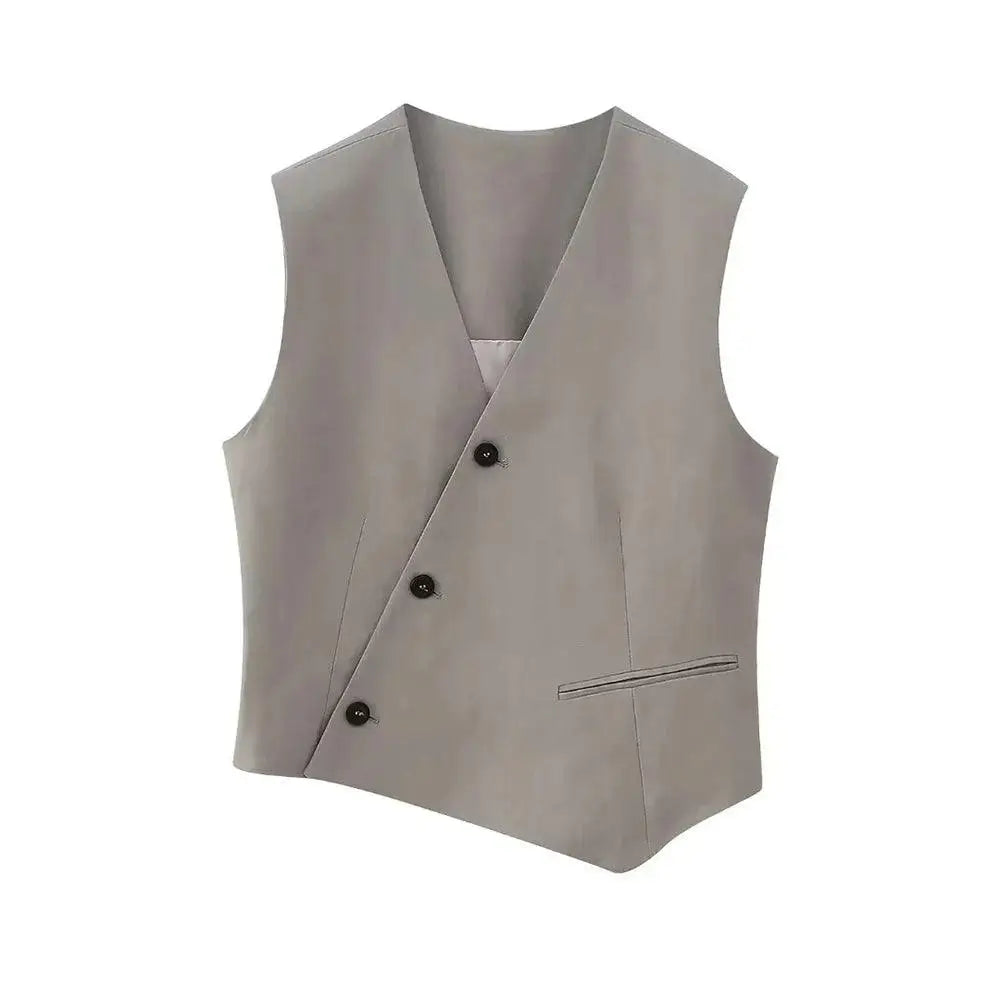 Colete feminino de alfaiataria cinza claro com design assimétrico, decote V, botões pretos diagonais e bolso falso, exibido em fundo branco.