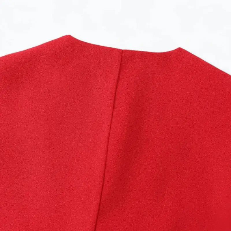 Close-up do decote arredondado e parte superior das costas do colete feminino de alfaiataria vermelho.