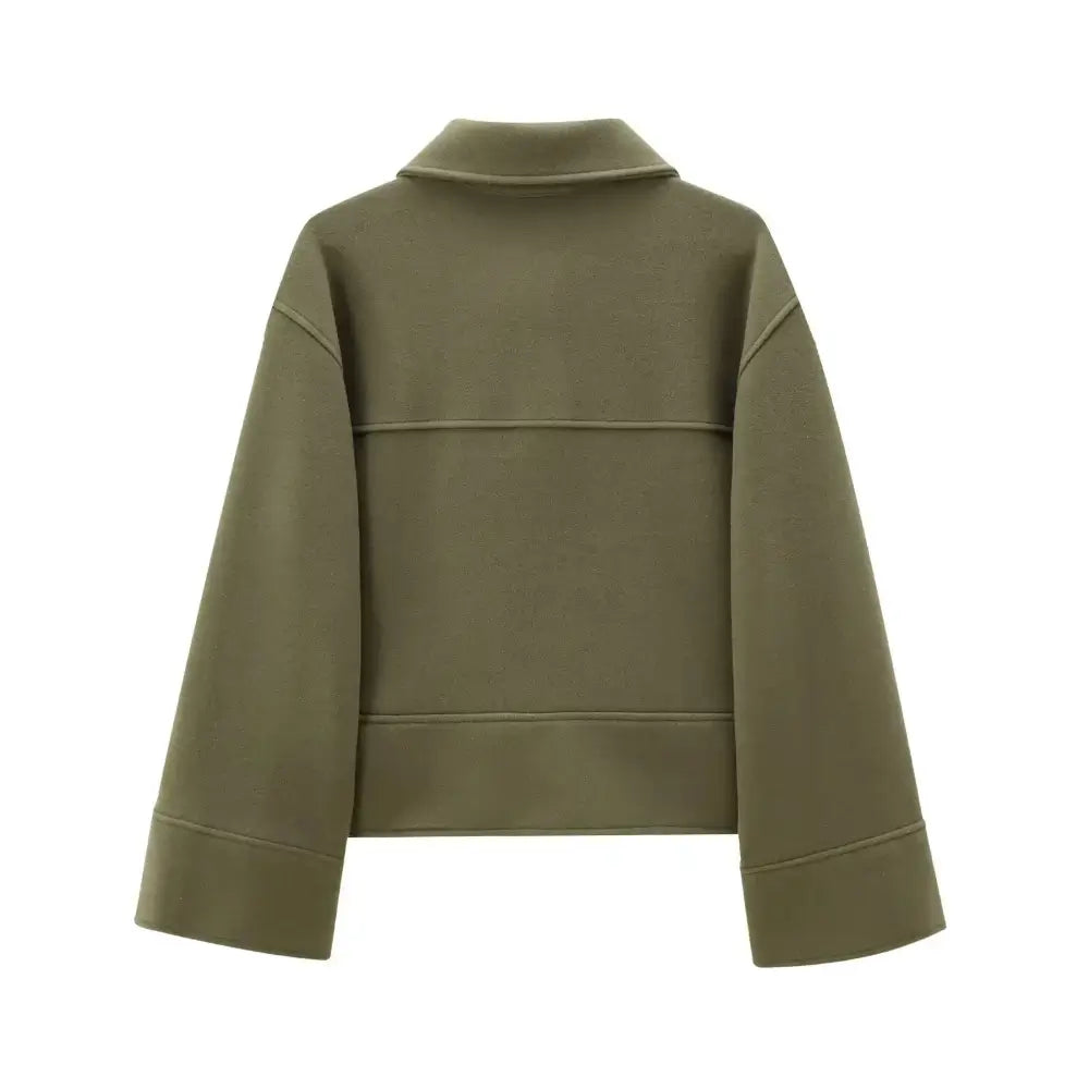 Vista traseira da jaqueta feminina de alfaiataria verde, com mangas amplas e detalhe de costura horizontal nas costas, em fundo branco.