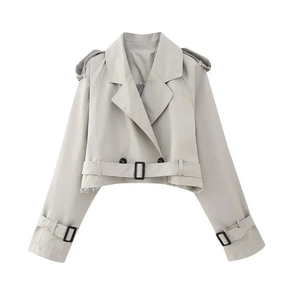 Jaqueta feminina cropped cinza estilo trench coat, com lapelas, botões pretos, cinto na barra e mangas longas com fivelas, exibida sobre fundo branco.