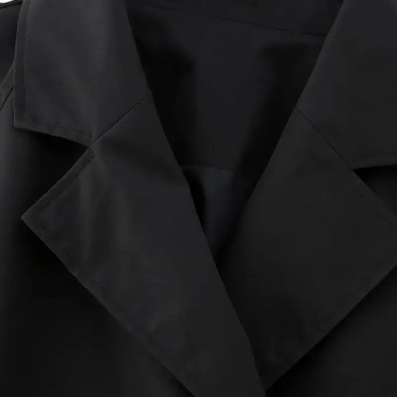 Close-up na gola da jaqueta feminina cropped preta estilo trench coat.