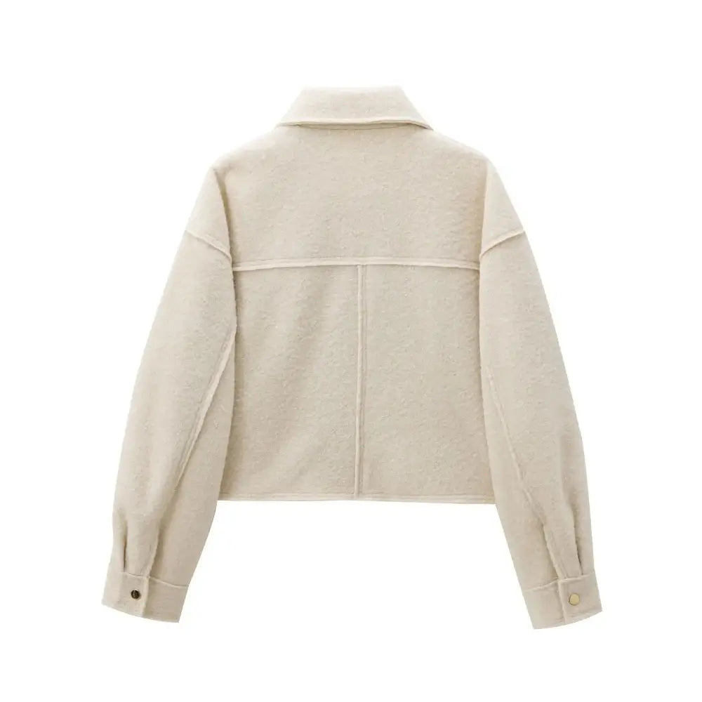 Vista traseira da jaqueta feminina off-white com textura de lã, detalhe de costuras nas costas e punhos, exibida sobre fundo branco.