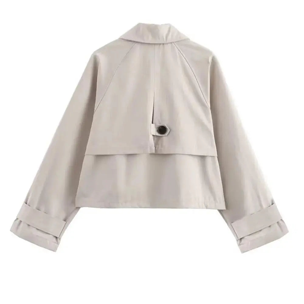 Vista traseira da jaqueta feminina cropped bege estilo trench coat, com botão preto nas costas, exibida em fundo branco.