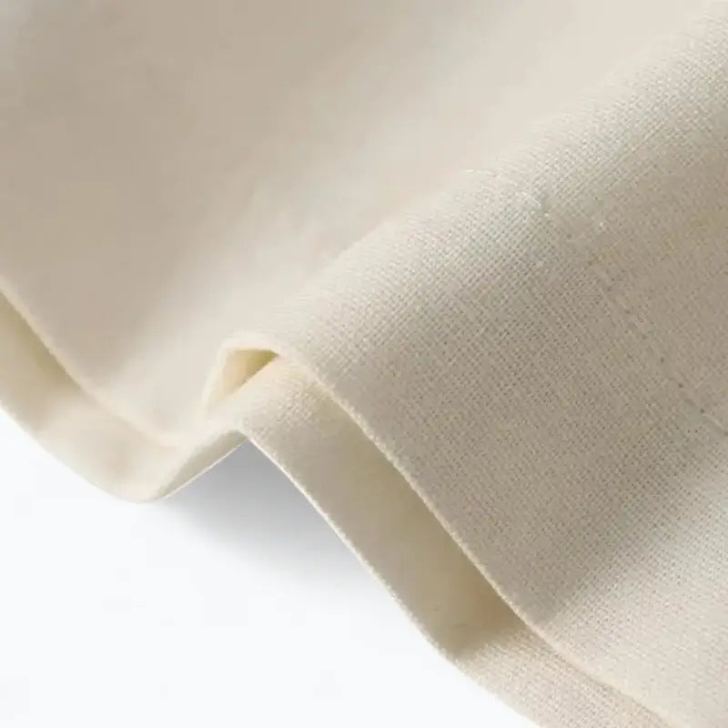 Close-up da textura e caimento liso do tecido de alfaiataria off white, em detalhe.