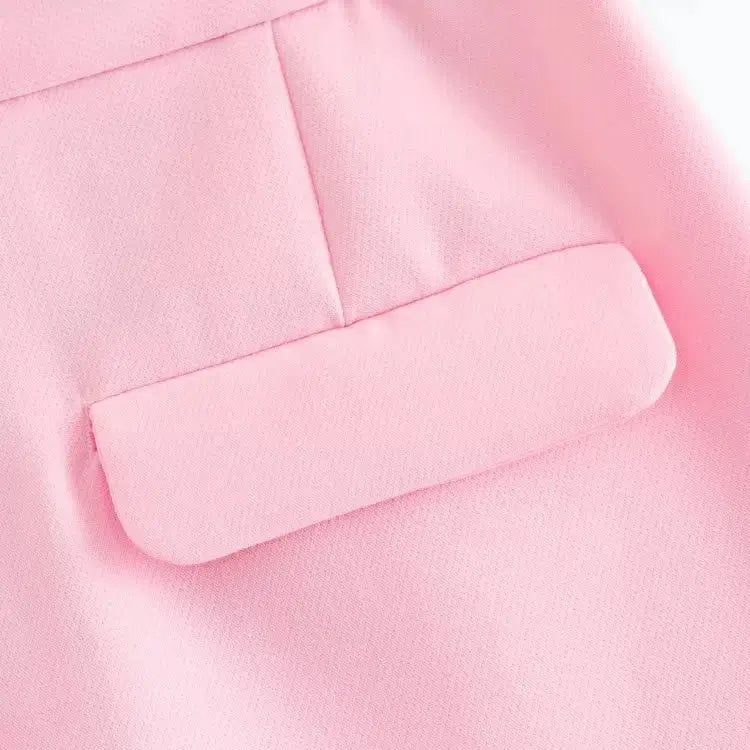 Close-up do bolso traseiro com aba, do short alfaiataria feminino rosa.