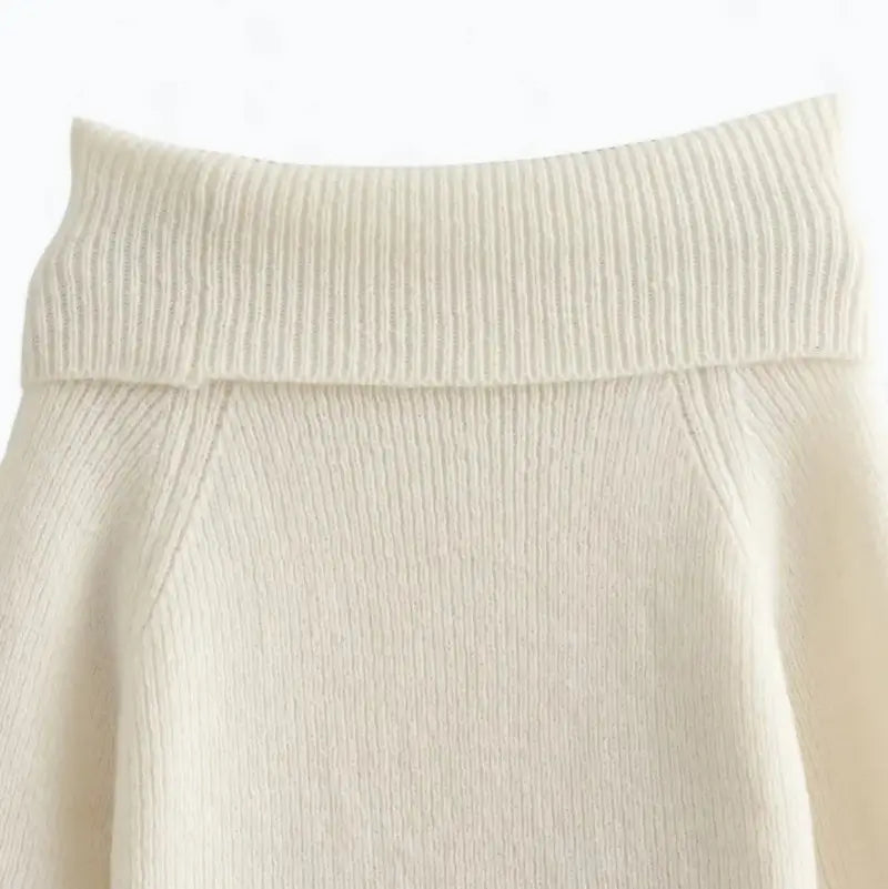 Close-up do suéter feminino off white, evidenciando a parte traseira do decote ombro a ombro e a textura canelada.